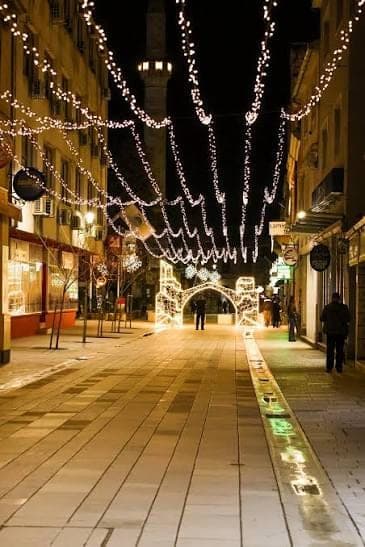 Fejićeva ulica u Mostaru noću, pješačka zona ukrašena svjetlima, u pozadini munara