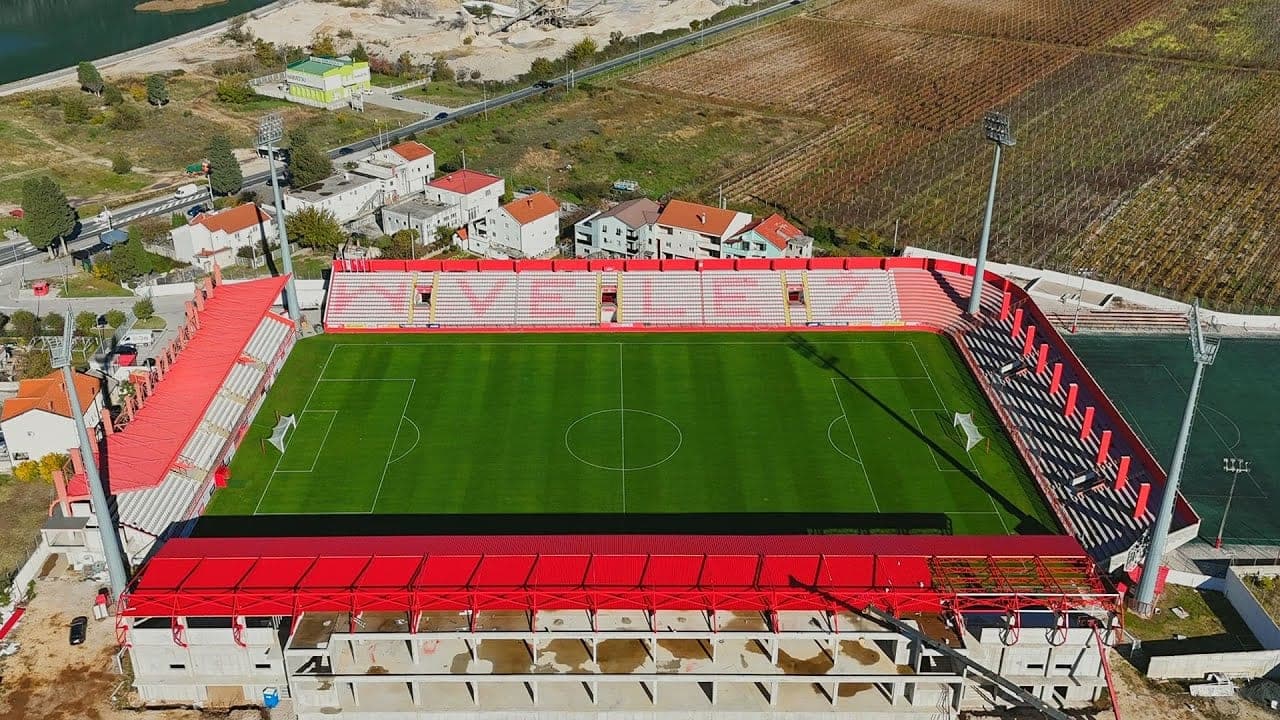 Stadion Rođeni iz zraka: teren, tribine s natpisom Velež i južna tribina s crvenim krovom u izgradnji