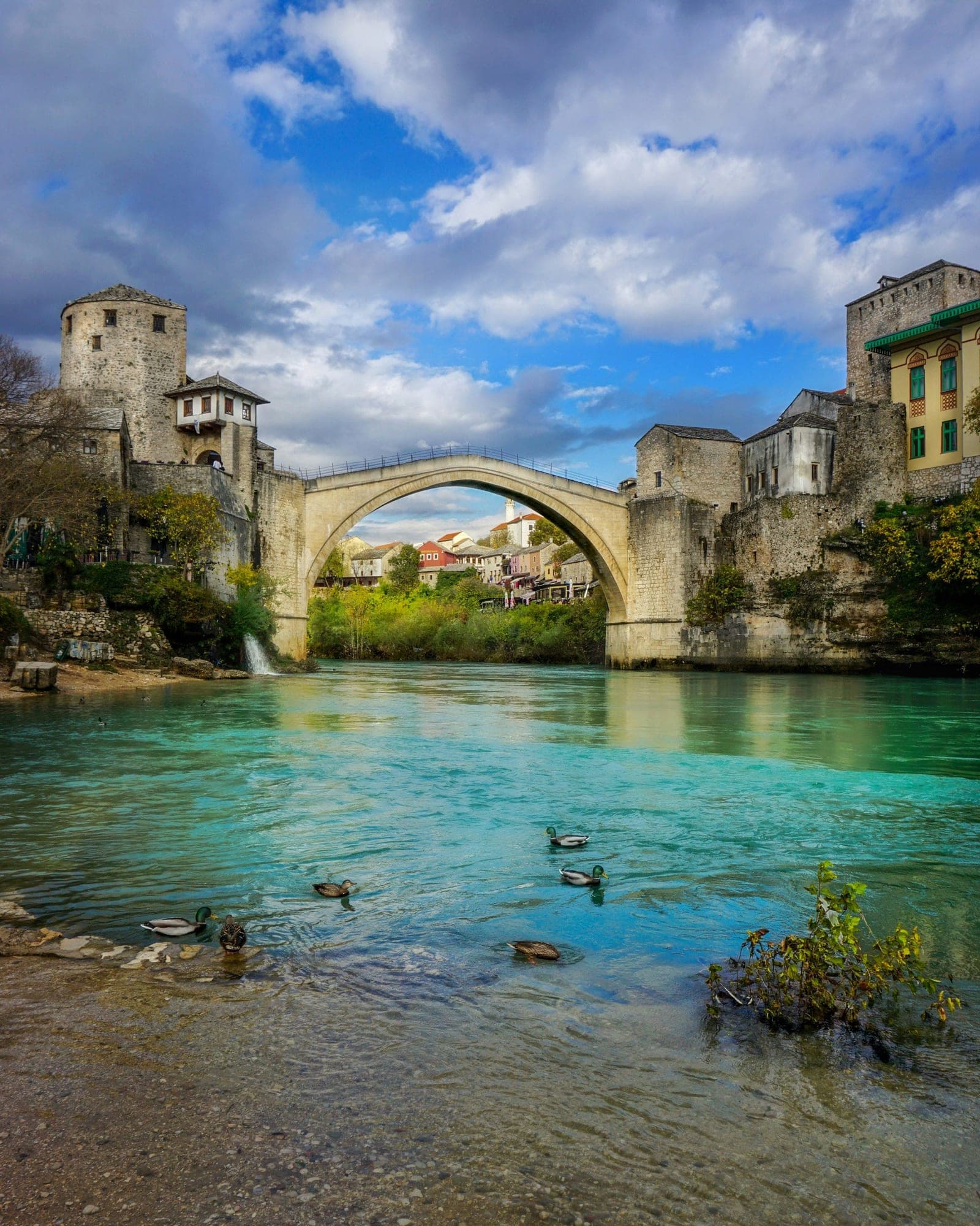 Stari most u Mostaru s obale Neretve, s kulama i kamenim kućama Starog grada uz obje obale